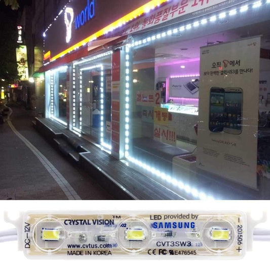 An illuminated storefront at night featuring bright LED lights with a sign advertising _CRYSTAL VISION lighting_, _LED provided by SAMSUNG_, and a website link, denoting the product is made in Korea