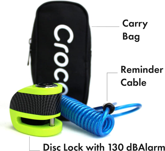 The image displays a security product composed of a disc lock featuring a loud 130 dB alarm, a reminder cable in a vibrant blue color, and a black carry bag with "Croco" visibly branded on it. The disc lock is highlighted with green and black colors, and its compact design suggests it is portable and possibly designed for motorbikes or bicycles. The reminder cable serves as an additional safety feature to prevent ride-away thefts. The carrying bag looks sturdy and convenient for storage and transport.