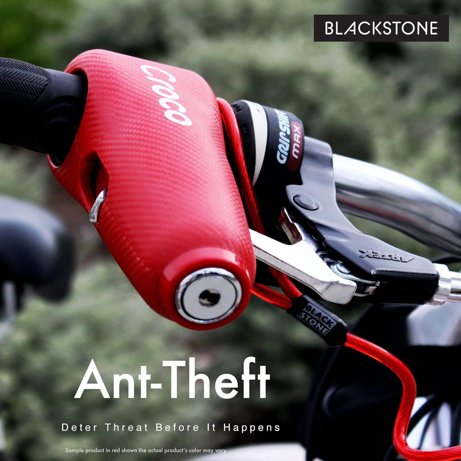 The image features a red Croco alarm lock attached to a bike's brake lever, suggesting its use as a theft deterrent. The product is part of the Blackstone brand, and the image emphasizes the anti-theft aspect of the device with the text "Deter Threat Before It Happens." A disclaimer notes that while the sample product is shown in red, the actual product's color may vary. The setting appears to be outdoors, possibly highlighting the lock's practical use in real-life scenarios